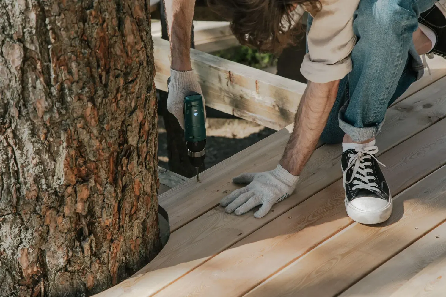 Deck repair in Marietta, GA: worker replacing and fastening deck boards