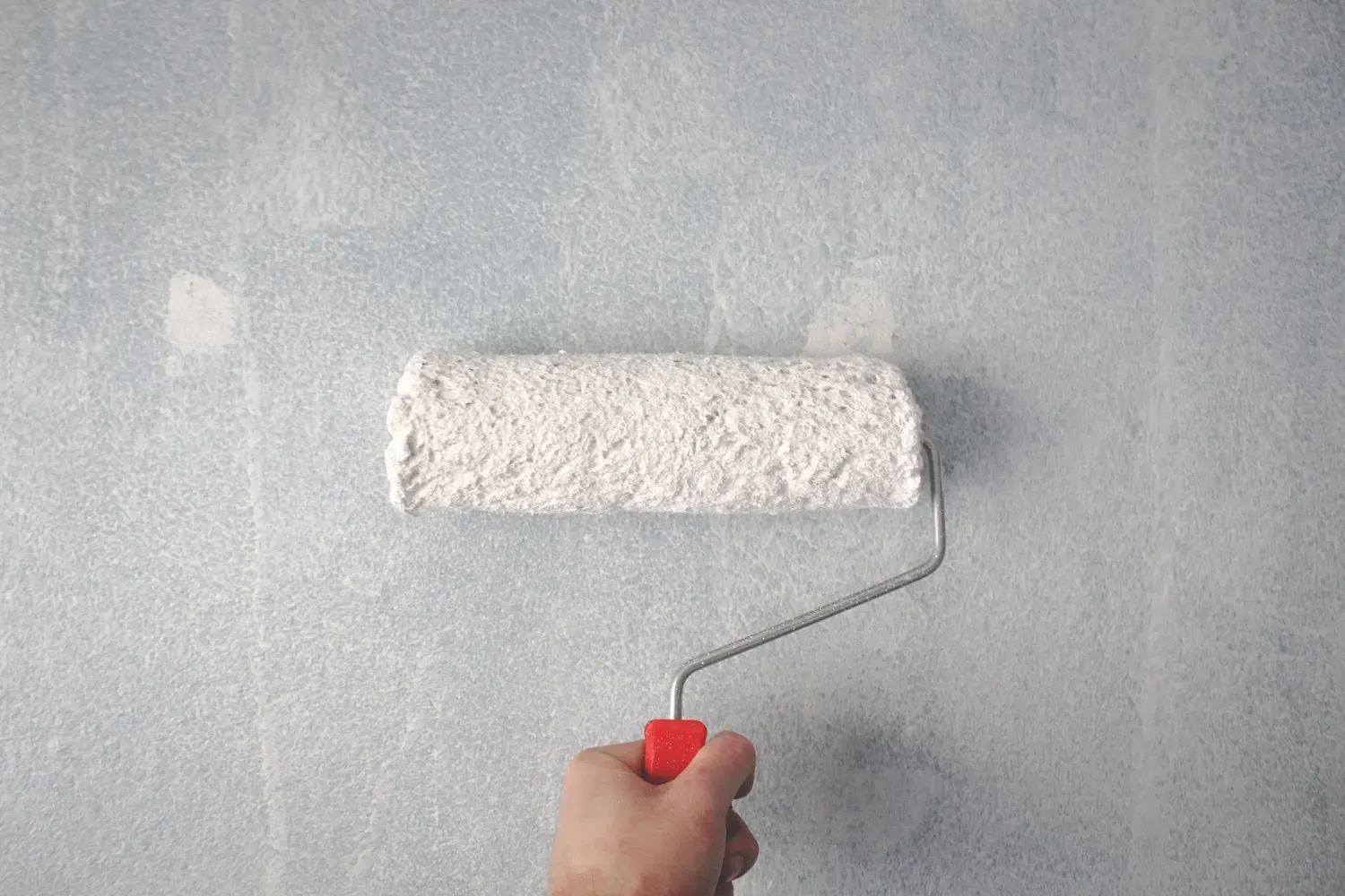 Interior painting in Marietta, GA: paint roller applying white paint to a wall