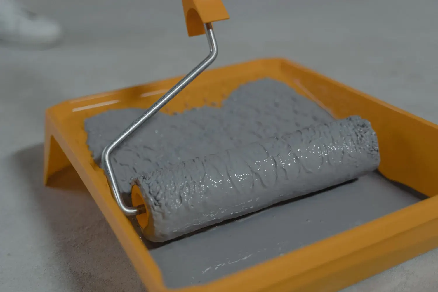 Interior painting in Marietta, GA: gray paint roller resting in a paint tray