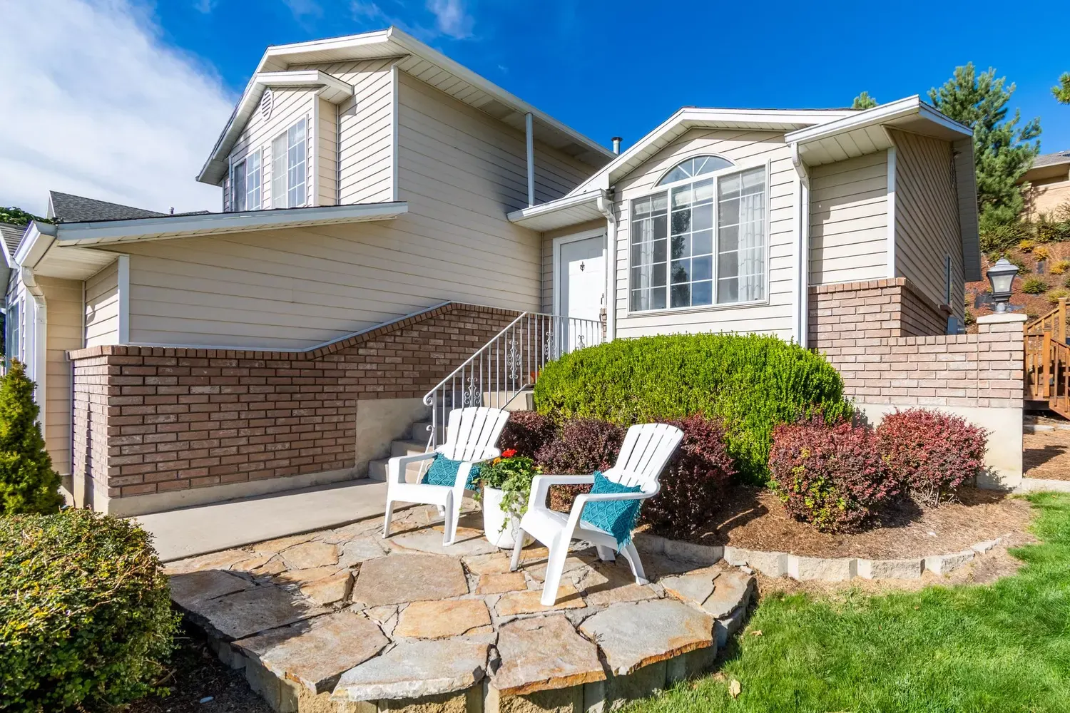 Painter in Atlanta, GA: brick and siding home with a stone patio and landscaped yard